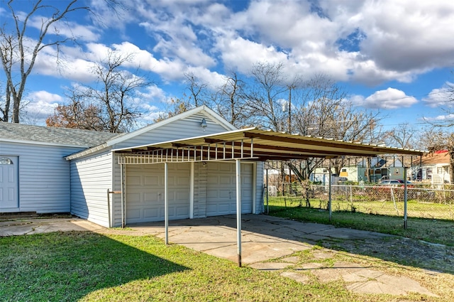 garage with a carport and a lawn