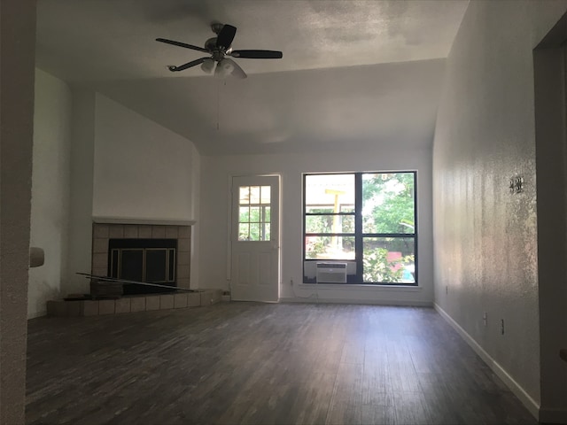 unfurnished living room featuring ceiling fan, lofted ceiling, a tiled fireplace, dark wood-type flooring, and cooling unit