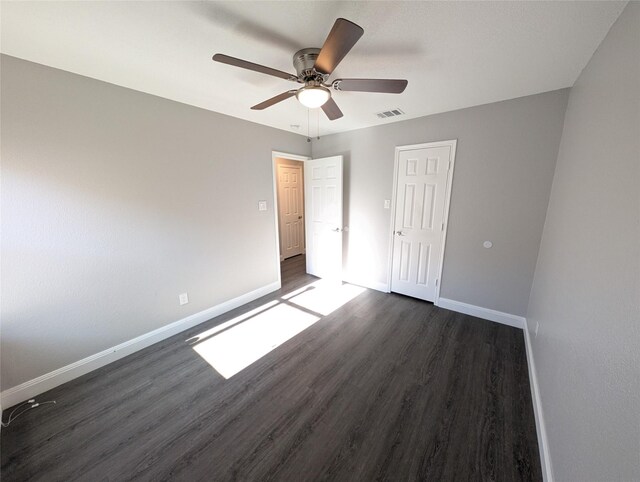 unfurnished bedroom featuring ceiling fan and dark wood-type flooring