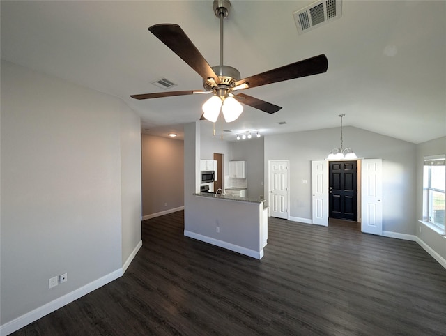 kitchen featuring stone counters, white cabinetry, dark wood-type flooring, vaulted ceiling, and ceiling fan with notable chandelier