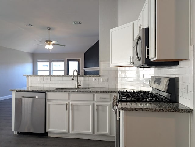 kitchen with sink, white cabinets, stainless steel appliances, and vaulted ceiling