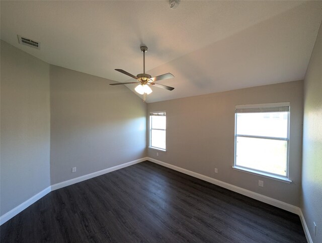 unfurnished room with plenty of natural light, ceiling fan, dark wood-type flooring, and vaulted ceiling