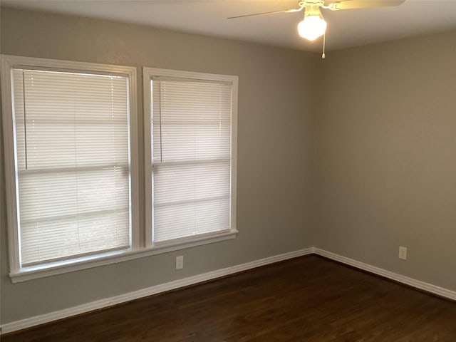 unfurnished room with ceiling fan and dark hardwood / wood-style flooring