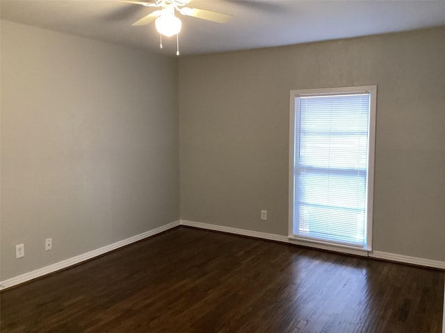 empty room featuring dark wood-type flooring and ceiling fan