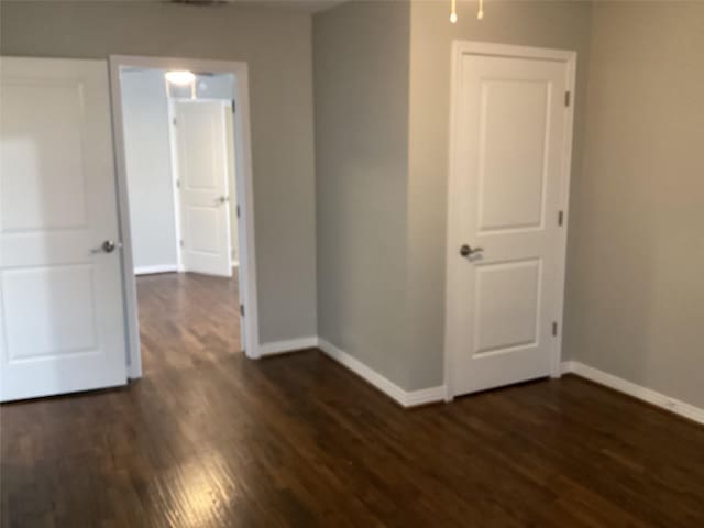 unfurnished bedroom featuring dark hardwood / wood-style floors