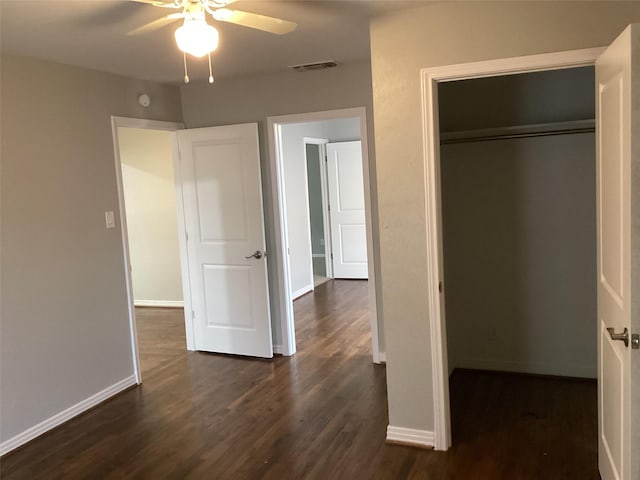 unfurnished bedroom featuring a closet, dark hardwood / wood-style floors, and ceiling fan