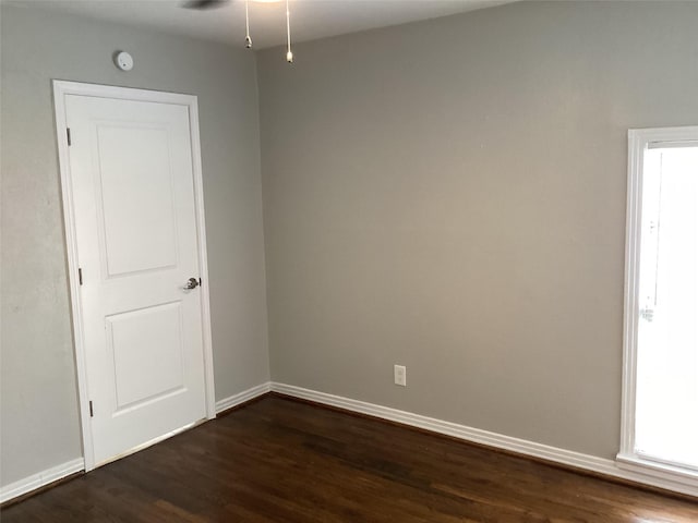 spare room featuring ceiling fan and dark wood-type flooring