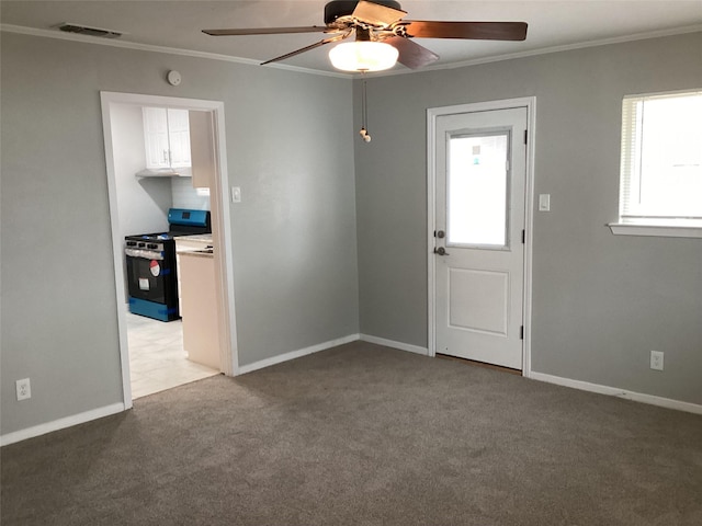 carpeted empty room with ceiling fan and ornamental molding