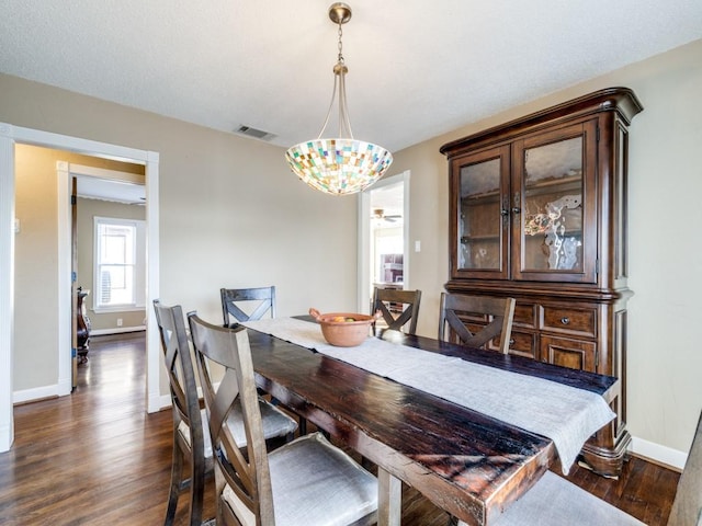 dining space with dark wood-type flooring and a notable chandelier