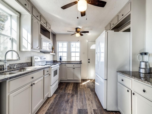 kitchen with dark hardwood / wood-style floors, sink, white cabinets, white appliances, and a textured ceiling