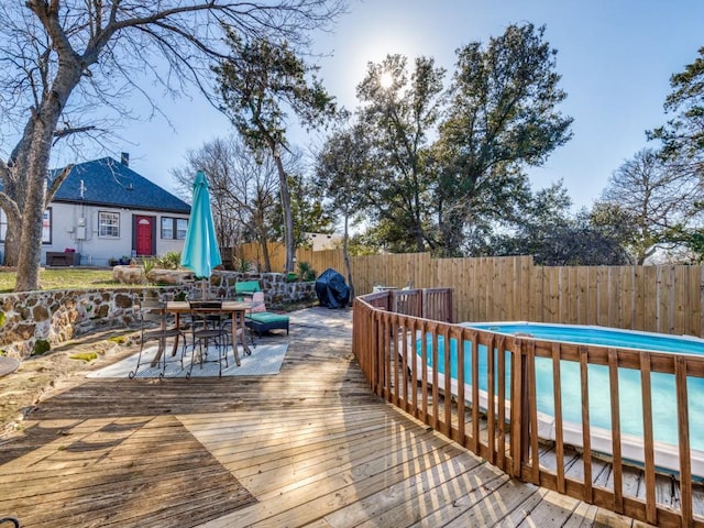 wooden deck with a fenced in pool