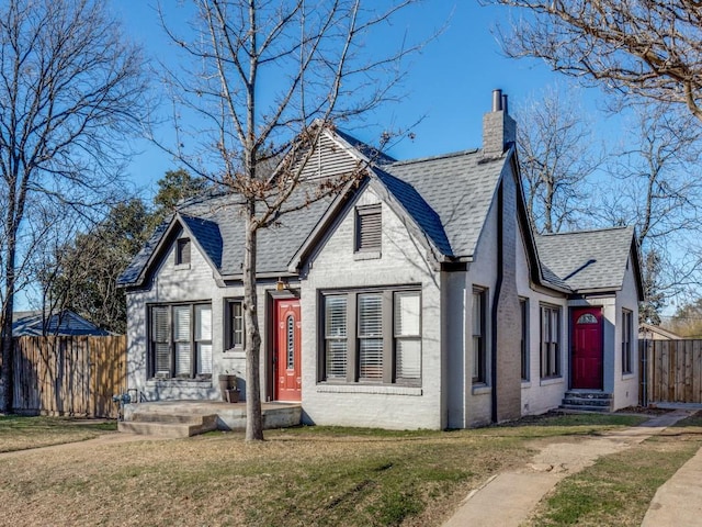 tudor home with a front lawn