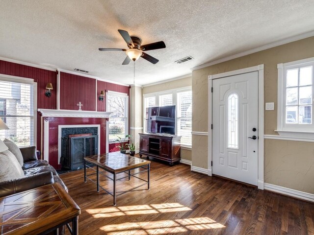 unfurnished living room featuring dark wood-type flooring, ornamental molding, and a wealth of natural light