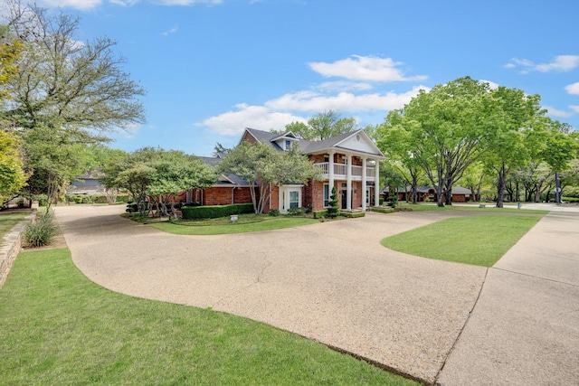 view of front facade featuring a balcony and a front lawn