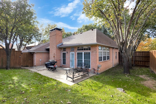 back of house featuring a patio area and a lawn