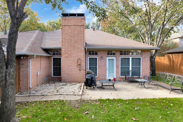 back of house featuring a lawn and a patio area