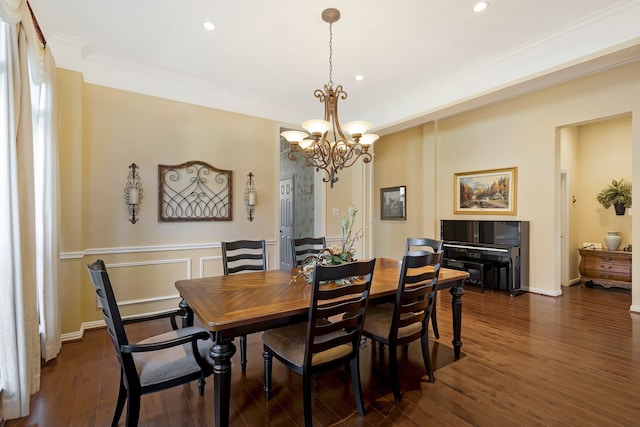 dining room with an inviting chandelier, ornamental molding, and dark hardwood / wood-style flooring