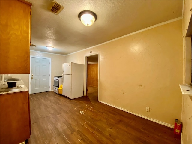 interior space with hardwood / wood-style flooring, crown molding, a textured ceiling, and white appliances