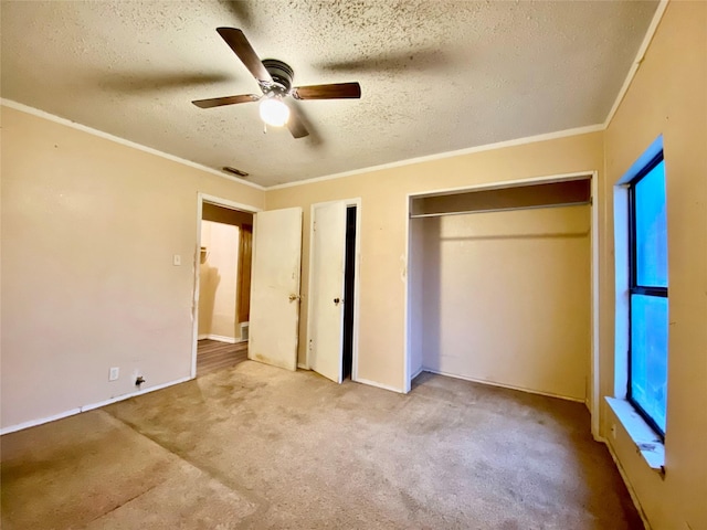 unfurnished bedroom featuring crown molding, light colored carpet, ceiling fan, and a textured ceiling