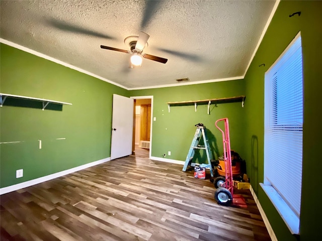 recreation room featuring wood-type flooring, ornamental molding, and a textured ceiling