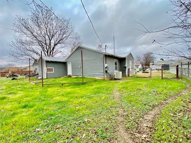 back of house with central AC and a lawn