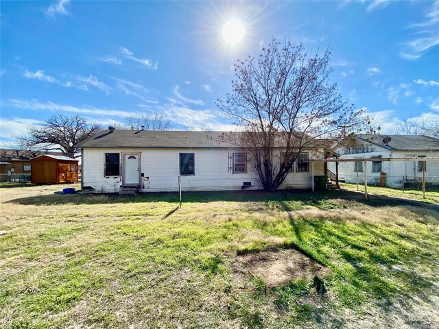 rear view of property featuring a lawn