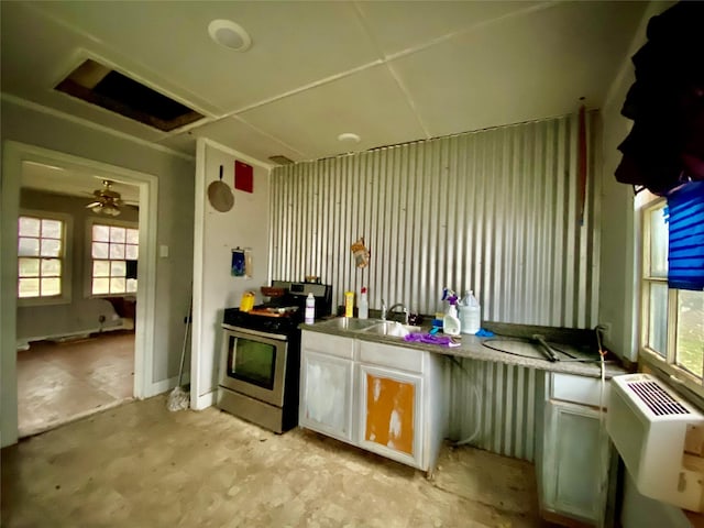 kitchen with an AC wall unit, ceiling fan, sink, and stainless steel range oven