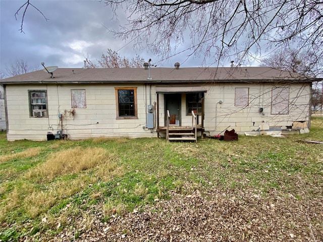 back of house with cooling unit and a lawn