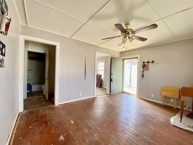 empty room featuring hardwood / wood-style flooring, a paneled ceiling, and ceiling fan