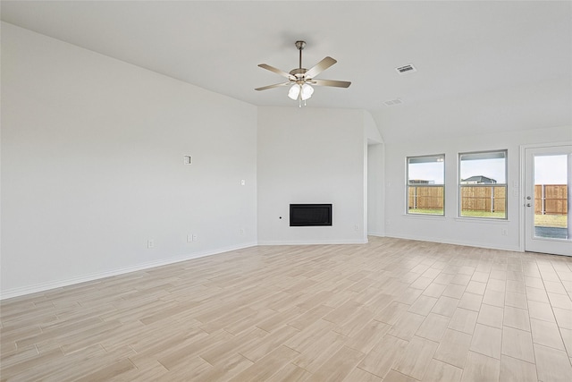 unfurnished living room with ceiling fan, vaulted ceiling, and light hardwood / wood-style floors