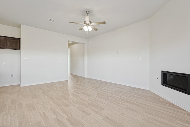 unfurnished living room featuring heating unit, ceiling fan, and light hardwood / wood-style floors