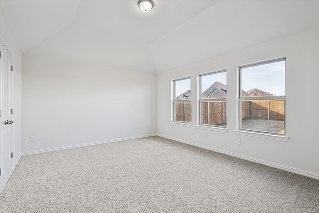 carpeted spare room featuring lofted ceiling