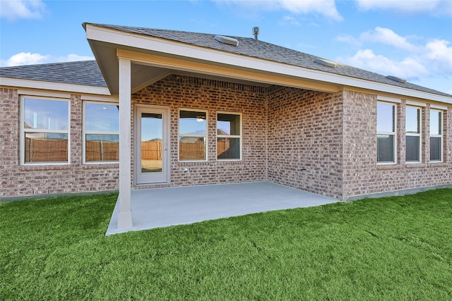 rear view of property featuring a yard and a patio area