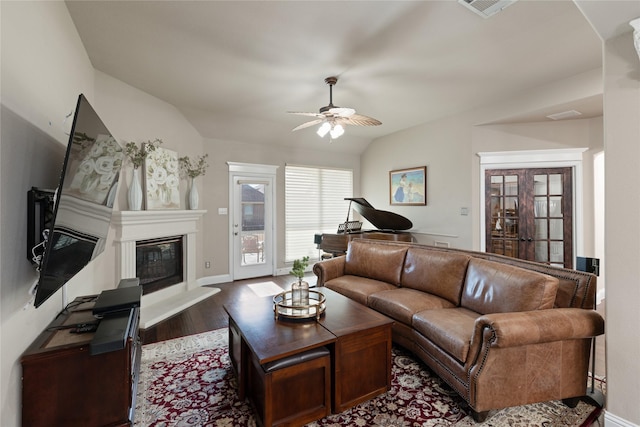 living room with ceiling fan, french doors, dark hardwood / wood-style floors, and vaulted ceiling