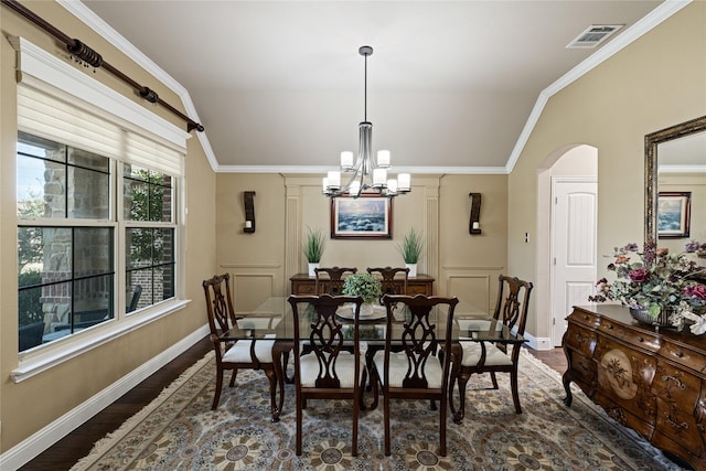 dining space featuring a chandelier, dark hardwood / wood-style flooring, ornamental molding, and vaulted ceiling