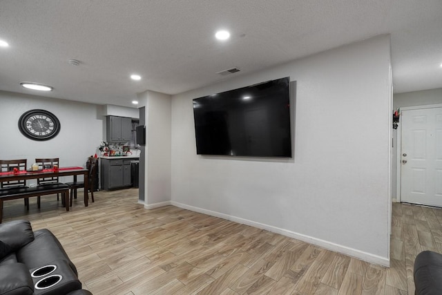 living room featuring a textured ceiling and light hardwood / wood-style floors