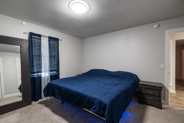 bedroom featuring dark colored carpet and a textured ceiling