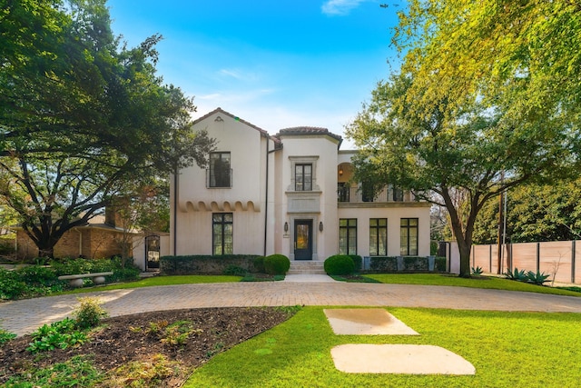 mediterranean / spanish home featuring a front lawn