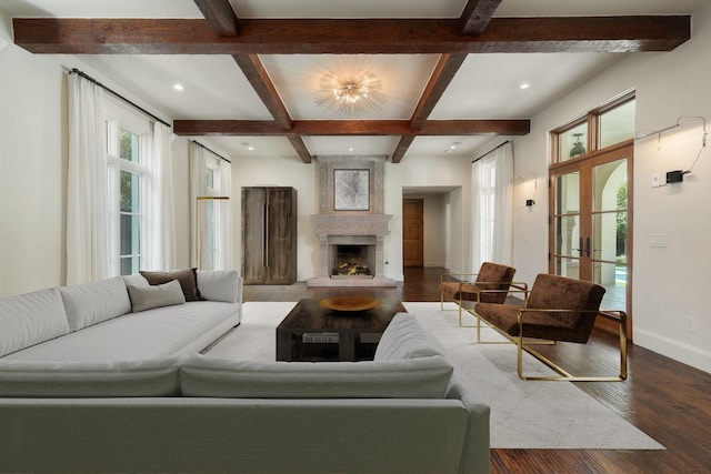 living room featuring hardwood / wood-style floors, coffered ceiling, a large fireplace, french doors, and beam ceiling