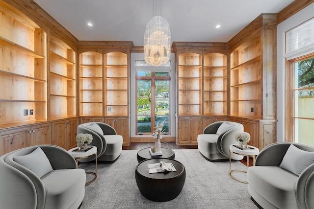 sitting room featuring built in shelves and a chandelier