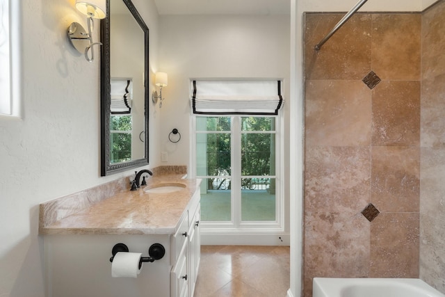 bathroom featuring tiled shower / bath combo, vanity, and a healthy amount of sunlight