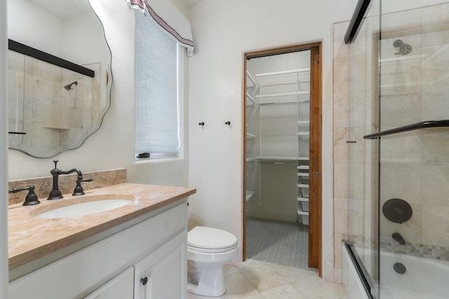 full bathroom with shower / bath combination with glass door, vanity, toilet, and tile patterned flooring