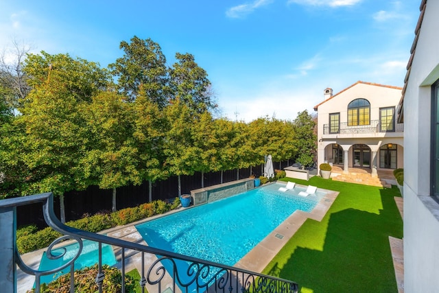 view of swimming pool featuring a patio area, a lawn, and a water slide