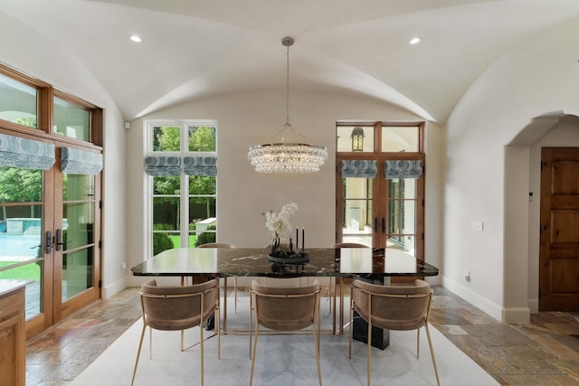 dining space with an inviting chandelier, lofted ceiling, and french doors