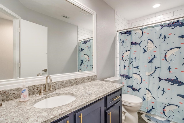 bathroom featuring a shower with curtain, vanity, and toilet