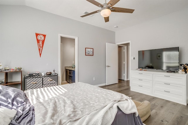 bedroom featuring connected bathroom, ceiling fan, hardwood / wood-style floors, and vaulted ceiling