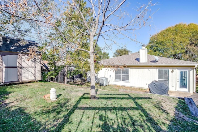 back of property featuring a shed and a yard