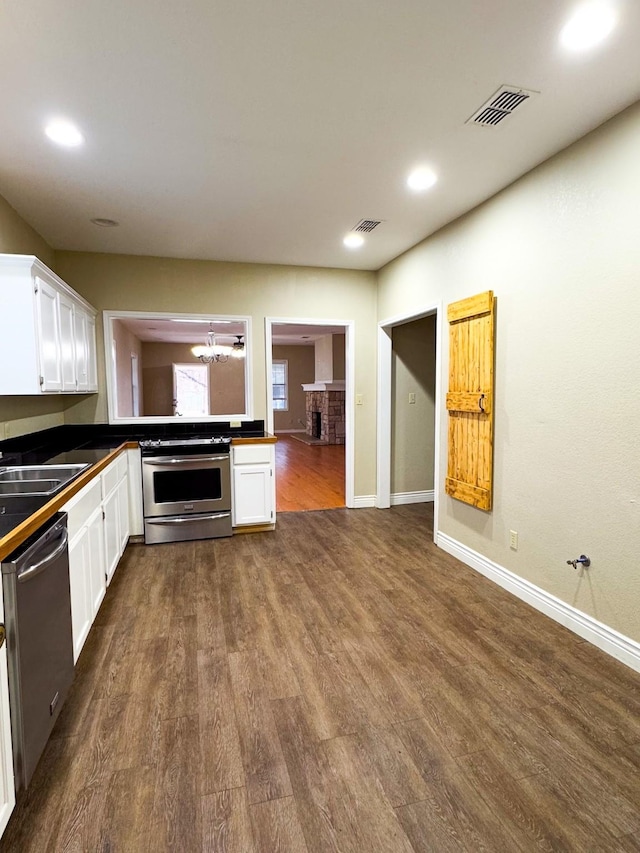 kitchen with white cabinetry, sink, appliances with stainless steel finishes, and an inviting chandelier