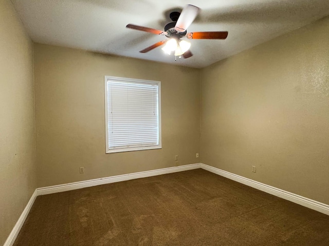 empty room featuring ceiling fan and dark colored carpet