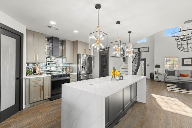 kitchen featuring gray cabinetry, stainless steel fridge with ice dispenser, range with electric stovetop, light stone countertops, and wall chimney range hood